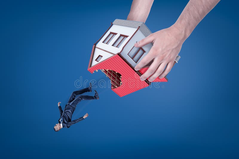 Nahaufnahme der Hände des Mannes, die Haus mit Loch im Dach umgedreht halten und heraus Kleinunternehmer fallenlassen stockfotos Nahaufnahme der Hände des Mannes, die Haus mit Loch im Dach umgedreht halten und heraus Kleinunternehmer fallenlassen stockfotos