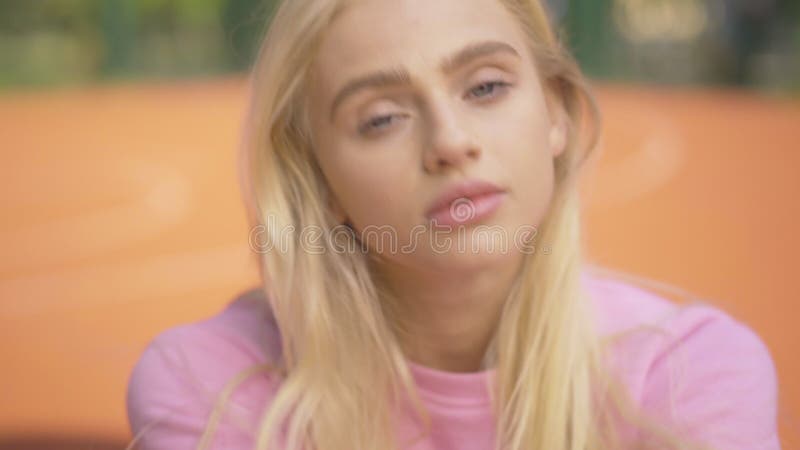 Nahaufnahme der jungen blonden Frau mit den grauen Augen, die Kamera und das Lächeln sehen. Porträt des Bezauberns des verlockende stock footage