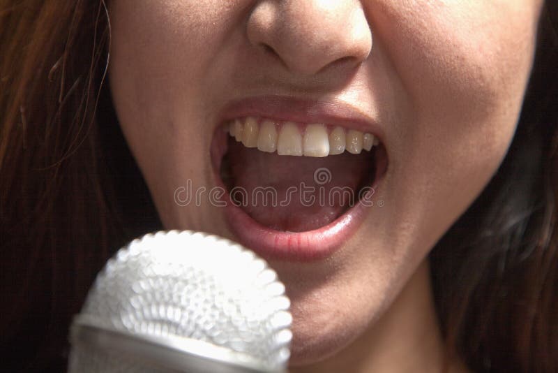 Nahaufnahme der jungen Frau singend in ein Mikrofon am Karaoke stockfotos Nahaufnahme der jungen Frau singend in ein Mikrofon am Karaoke stockfotos