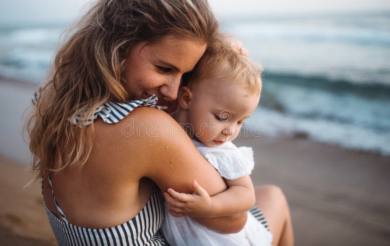 Nahaufnahme der jungen Mutter mit einem Kleinkindm?dchen auf Strand an den Sommerferien lizenzfreie stockfotografie Nahaufnahme der jungen Mutter mit einem Kleinkindm?dchen auf Strand an den Sommerferien lizenzfreie stockfotografie