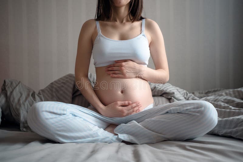 Nahaufnahme der schwangeren Frau ihren Bauch mit ihren Händen über und unter halten, Meditation lizenzfreies stockbild Nahaufnahme der schwangeren Frau ihren Bauch mit ihren Händen über und unter halten, Meditation lizenzfreies stockbild