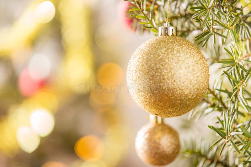Nahaufnahme des Goldweihnachtsballs, der am Weihnachtsbaum hängt lizenzfreies stockfoto Nahaufnahme des Goldweihnachtsballs, der am Weihnachtsbaum hängt lizenzfreies stockfoto