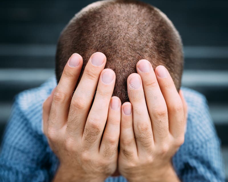 Nahaufnahme des verzweifelten jungen Mannes, der sein Gesicht mit den Händen bedeckt stockbilder Nahaufnahme des verzweifelten jungen Mannes, der sein Gesicht mit den Händen bedeckt stockbilder