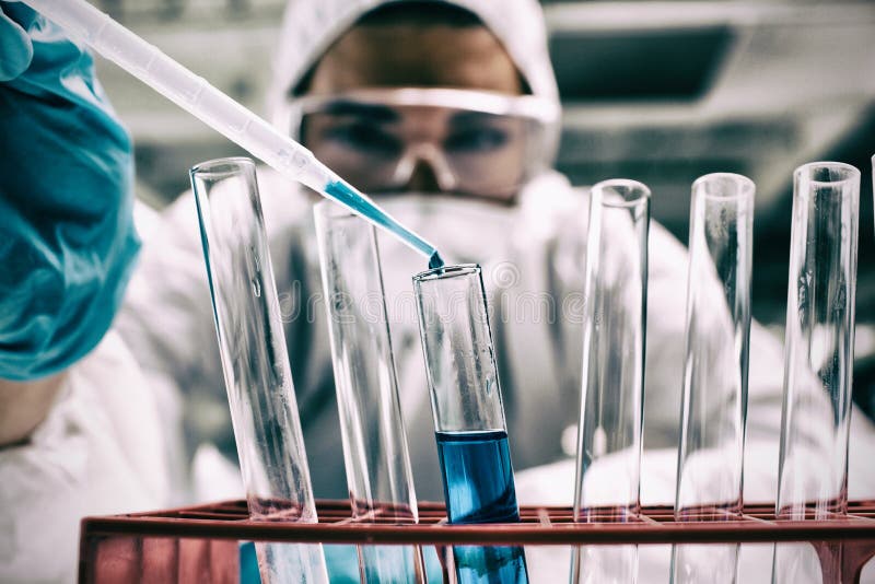 Nahaufnahme des Wissenschaftsstudenten blaue Flüssigkeit im Reagenzglas fallenlassend lizenzfreies stockbild Nahaufnahme des Wissenschaftsstudenten blaue Flüssigkeit im Reagenzglas fallenlassend lizenzfreies stockbild