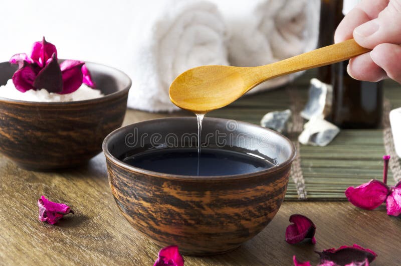 Nahaufnahme des Öls für Massage in der Schüssel und in anderen kosmetischen Produkten Frau, die kosmetisches Öl für Schönheitsver lizenzfreie stockbilder Nahaufnahme des Öls für Massage in der Schüssel und in anderen kosmetischen Produkten Frau, die kosmetisches Öl für Schönheitsver lizenzfreie stockbilder