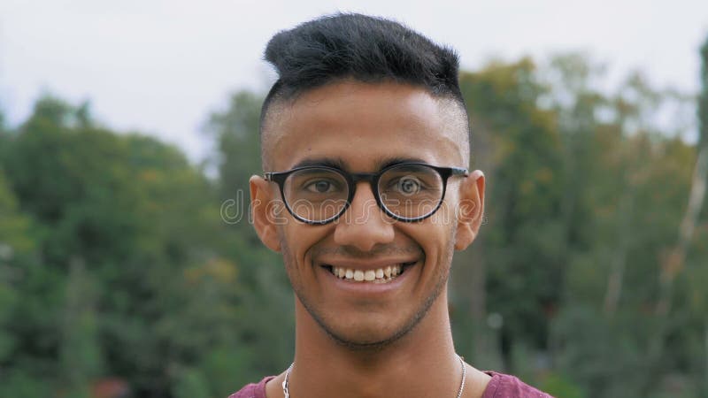 Nahaufnahme-schöner indischer Kerl in den Glas-Blicken und dem Lachen