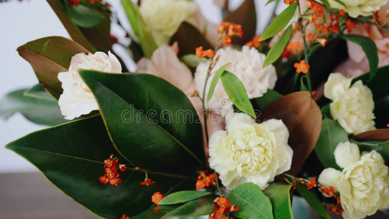 Nahaufnahmeblumengesteck Blumen in einem Glasvase Frau, die frische Blumen auswählt, um schönen Blumenstrauß im Vase herzustellen