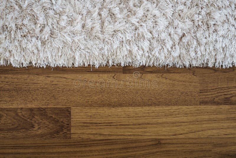 Nahaufnahmeflaumiger Luxusteppich auf lamellenförmig angeordnetem Holzfußboden stockfoto Nahaufnahmeflaumiger Luxusteppich auf lamellenförmig angeordnetem Holzfußboden stockfoto