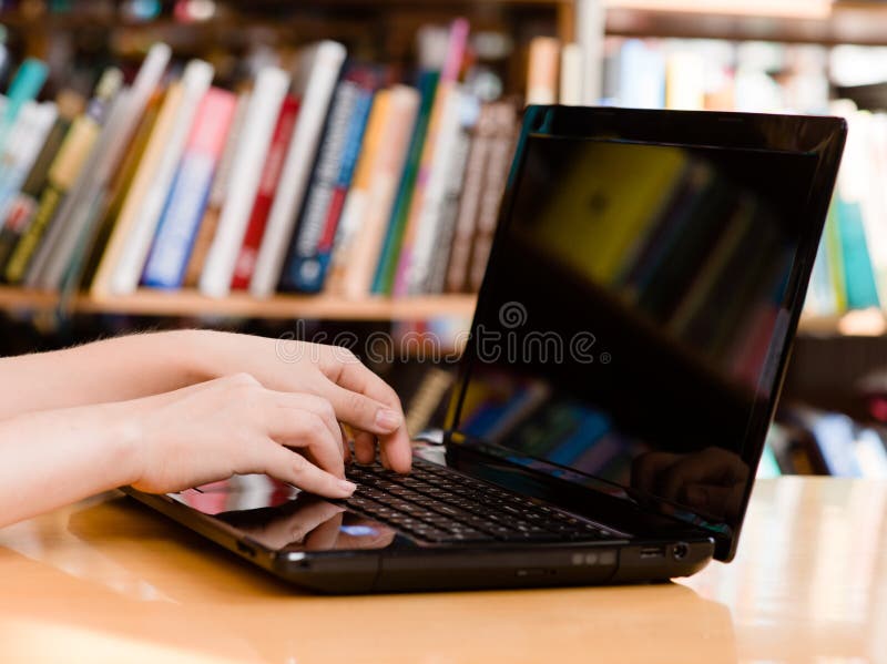 Nahaufnahmehände, die auf Notizbuch in der Bibliothek schreiben lizenzfreie stockbilder