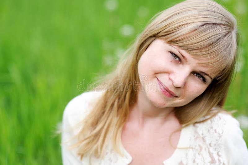 Close-up portrait of beautiful young blond woman in white blouse posing outdoors. Close-up portrait of beautiful young blond woman in white blouse posing outdoors