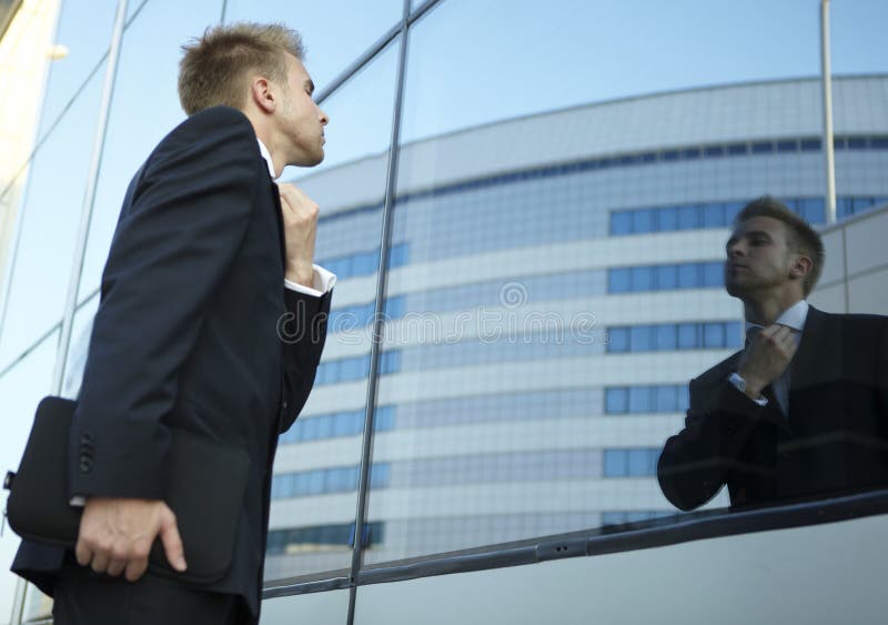 Vain business man checking his looks in the mirror. Vain business man checking his looks in the mirror