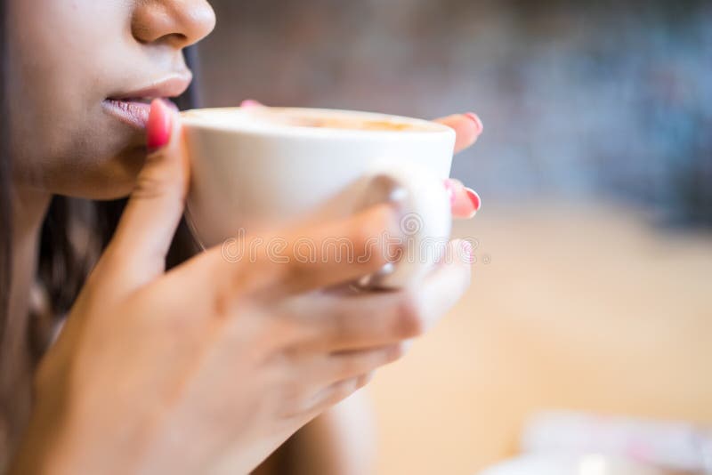 Nahaufnahmeporträt der jungen Frau mit Kaffeegetränk stockbild Nahaufnahmeporträt der jungen Frau mit Kaffeegetränk stockbild