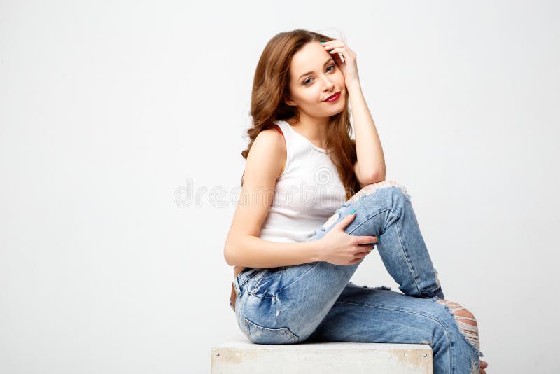 Nahaufnahmeporträt der schönen jungen Frau mit dem herrlichen Haar und natürlichen dem Make-up, die auf einem weißen Würfel sitzt stockbilder Nahaufnahmeporträt der schönen jungen Frau mit dem herrlichen Haar und natürlichen dem Make-up, die auf einem weißen Würfel sitzt stockbilder