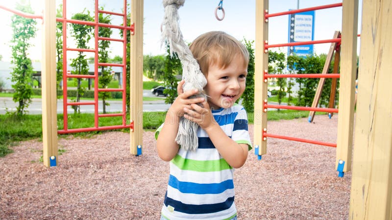 Nahaufnahmeporträt des entzückenden Lächelns glücklich wenig Junge auf Kinderspielplatz am Park lizenzfreie stockbilder Nahaufnahmeporträt des entzückenden Lächelns glücklich wenig Junge auf Kinderspielplatz am Park lizenzfreie stockbilder