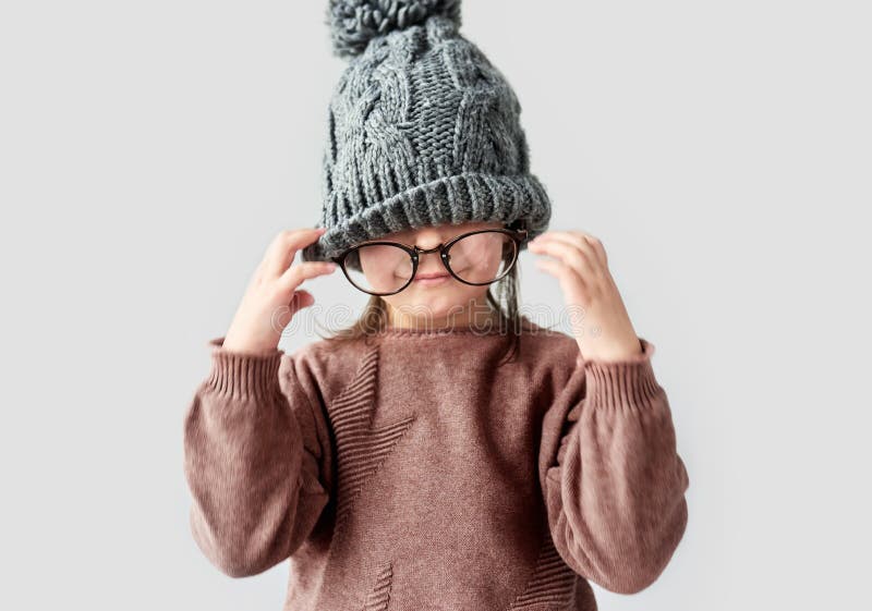 Nahaufnahmeporträt des netten lustigen kleinen Mädchens, das im warmen Hut des Winters, tragende Strickjacke mit runden stilvolle stockfotografie Nahaufnahmeporträt des netten lustigen kleinen Mädchens, das im warmen Hut des Winters, tragende Strickjacke mit runden stilvolle stockfotografie