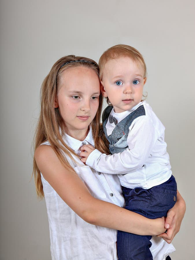 Nahaufnahmeporträt eines Bruders und der Schwester kleiner Junge, der seine ältere Schwester umarmt stockfotografie