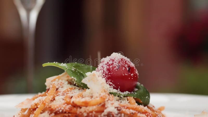 Nahaufstrekle gegrillter Käsesparmesan zum frischen Pasta-Gericht auf Teller im Restaurant