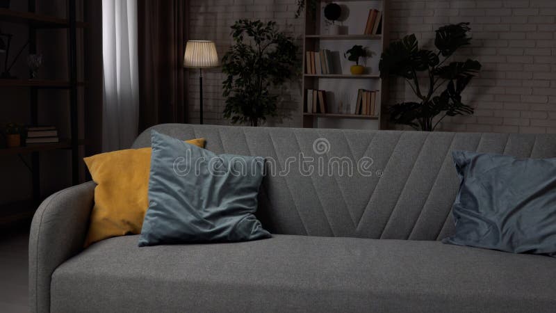 Nahe Aufnahme des Wohnzimmers in gemütlicher Wohnung modernes Sofa in der Mitte des Zimmers mit farbenfrohen Kissen tief stehend lizenzfreies stockfoto