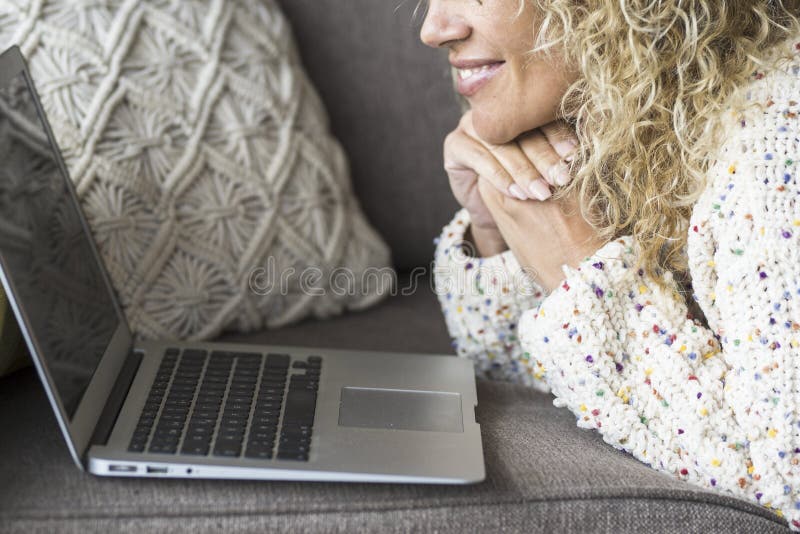 Nahe der Frau lächeln und mit einem glücklichen Laptop auf dem Sofa. fröhliche Frau vor dem Computer. Internetsurfer zu Hause lizenzfreies stockbild