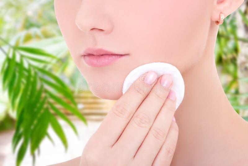 Nahes hohes Porträt der jungen Schönheit ihre Gesichtshaut durch Baumwollauflage säubernd stockbild Nahes hohes Porträt der jungen Schönheit ihre Gesichtshaut durch Baumwollauflage säubernd stockbild