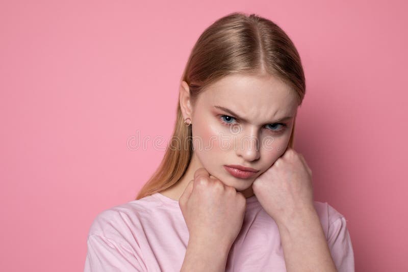 Nahes hohes Portr?t des jungen sch?nen betonten ver?rgerten M?dchens, das F?uste auf Gesicht h?lt stockfotografie Nahes hohes Portr?t des jungen sch?nen betonten ver?rgerten M?dchens, das F?uste auf Gesicht h?lt stockfotografie