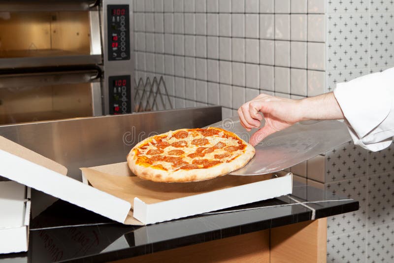 Nahrungsmittellieferung in Ihrem Haus oder Büro. Koch ist frisch zubereitete Pizza in einer Kiste.