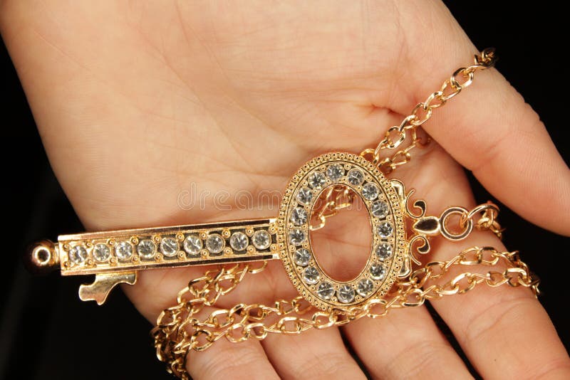 golden key in female hand over dark background royalty free stock photography golden key in female hand over dark background royalty free stock photography