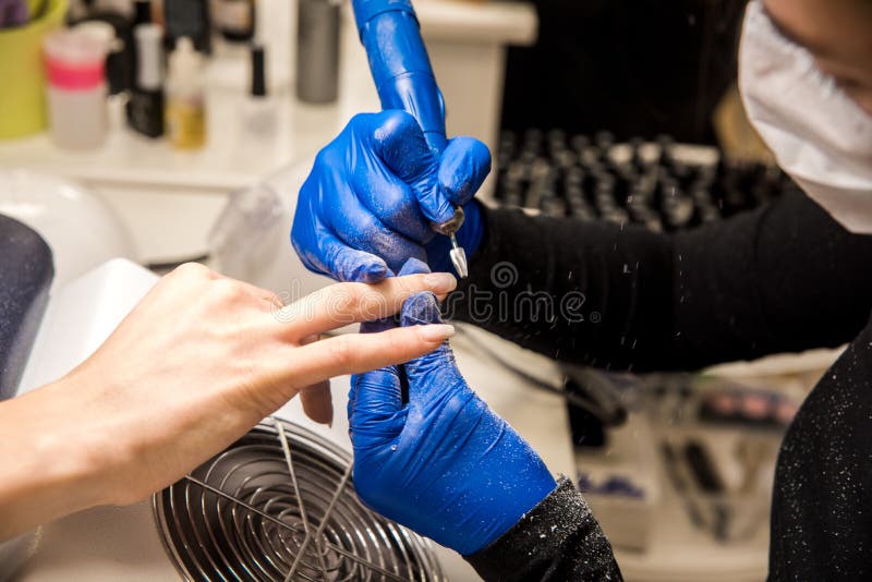 Nail Tech Filing Nails with Nail File. Professional Manicure Tools