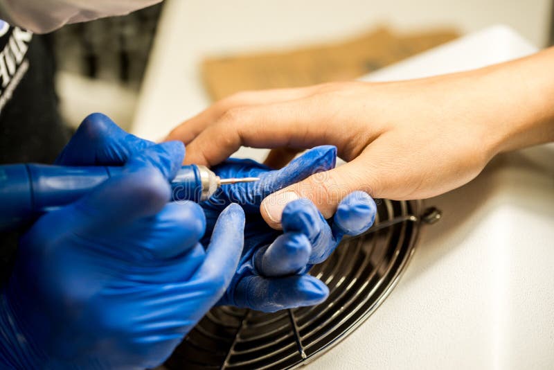 Nail Tech Filing Nails with Nail File. Professional Manicure Tools