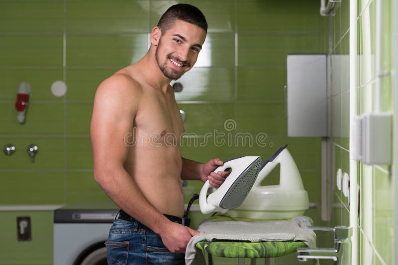 Happy Naked Handsome Man Ironing Clothes Housework.