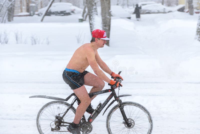A naked man rides a bike during snowfall in winter in Moscow royalty free stock images A naked man rides a bike during snowfall in winter in Moscow royalty free stock images