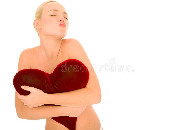 Naked woman with heart-shaped pillow