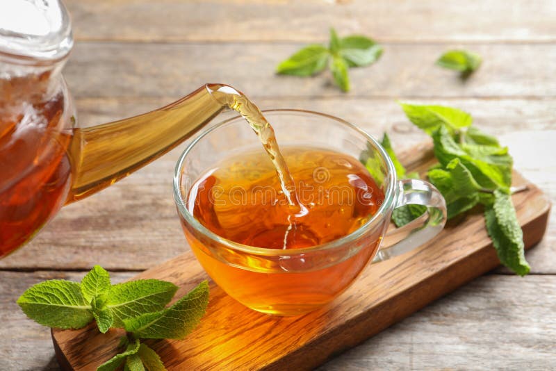 Nalewać gorącej aromatycznej nowej herbaty w filiżankę zdjęcia stock Nalewać gorącej aromatycznej nowej herbaty w filiżankę zdjęcia stock