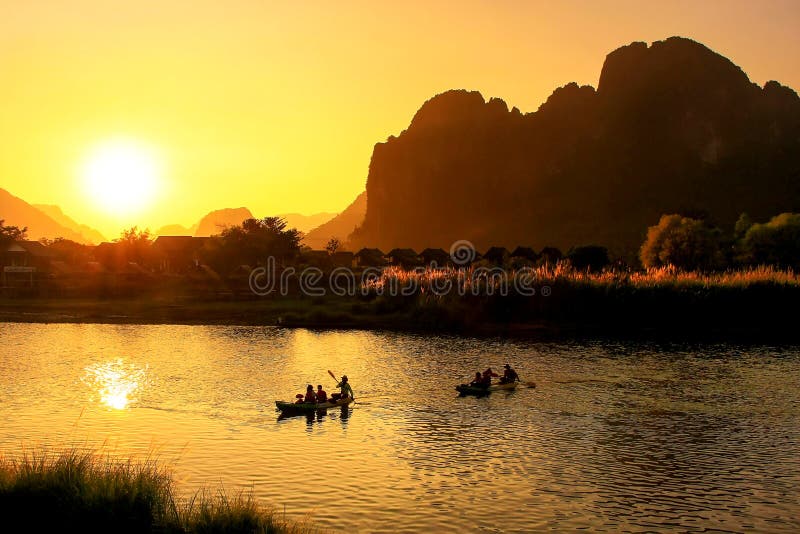 Nam Song River på solnedgången med silhouetted vaggar bildande och kaen royaltyfri fotografi Nam Song River på solnedgången med silhouetted vaggar bildande och kaen royaltyfri fotografi