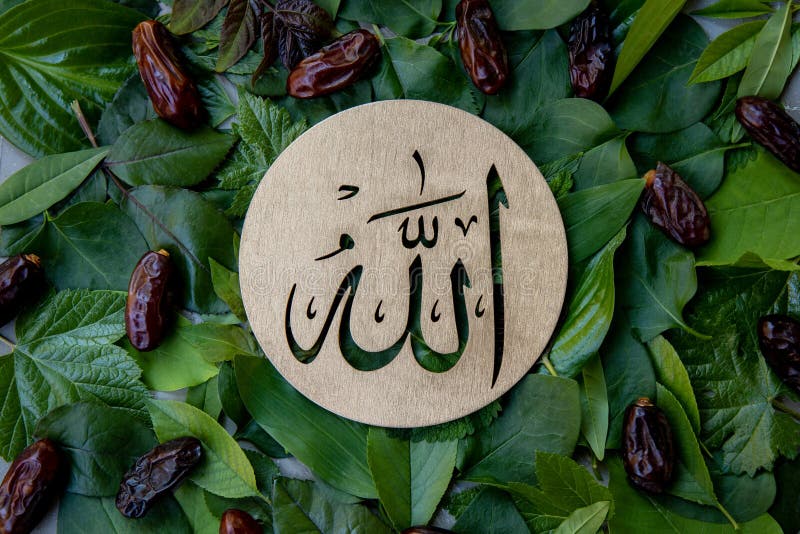 Name of Allah in Arabic on Gold Wood, Green Leaves and Dates Fruit  Background. Calligraphy Means the God Al Mighty of Stock Photo - Image of  religious, allah: 231519654