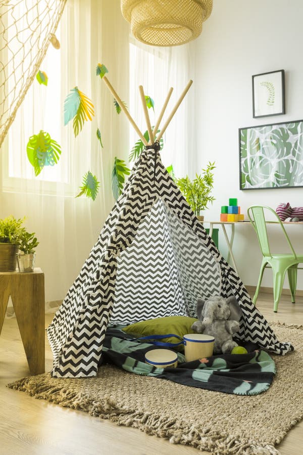 Black and white tent in the middle of creatively decorated children`s room. Black and white tent in the middle of creatively decorated children`s room