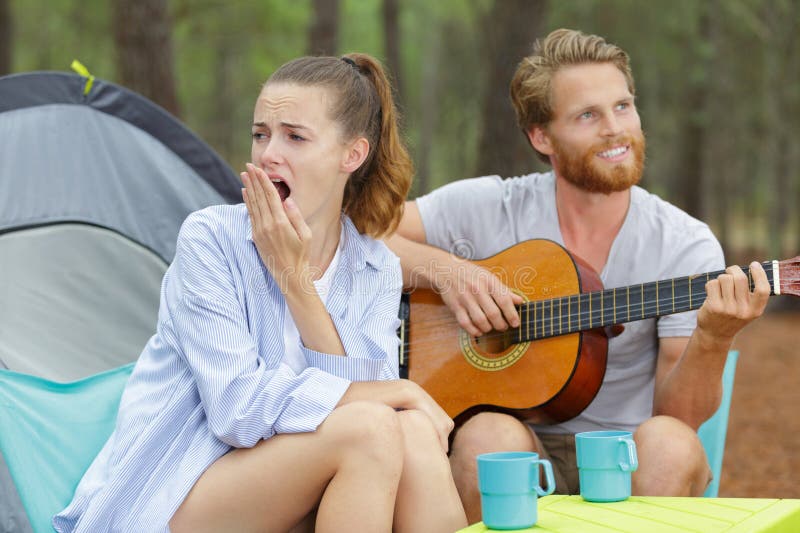 Namorada entediada como namorado não para de tocar violão fotos de stock royalty free
