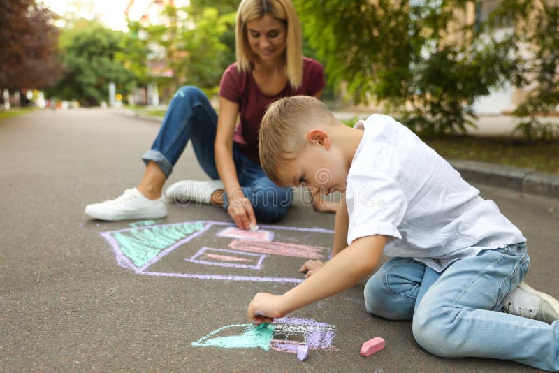 Nanny with cute little boy drawing house with chalks royalty free stock photos Nanny with cute little boy drawing house with chalks royalty free stock photos
