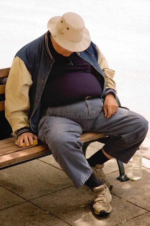 A heavy older gentleman who has fallen asleep on a city bench. A heavy older gentleman who has fallen asleep on a city bench.