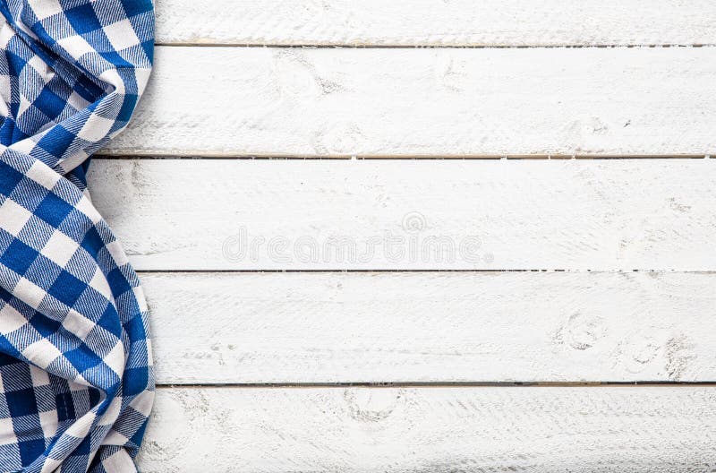 Blue checkered kitchen tablecloth on wooden table. Blue checkered kitchen tablecloth on wooden table.