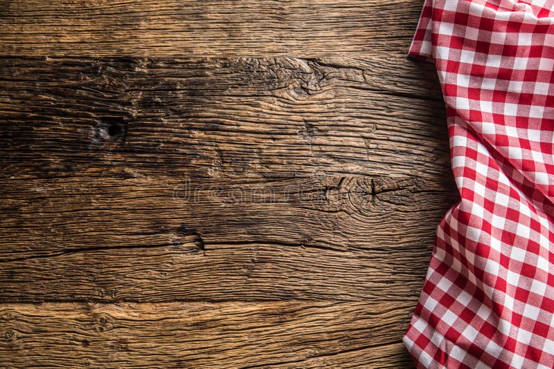 Red checkered kitchen tablecloth on rustic wooden table. Red checkered kitchen tablecloth on rustic wooden table.