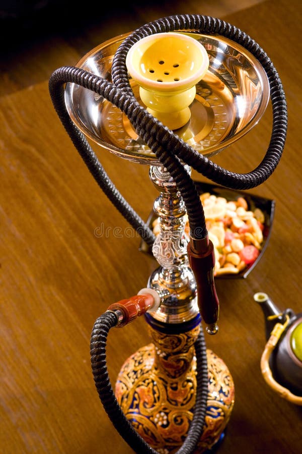 Arabic hookah with woman's reflection and dried fruit. Arabic hookah with woman's reflection and dried fruit