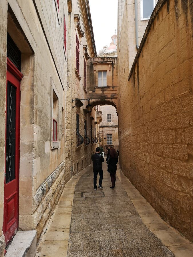 Narow street in Mdina, Malta. House with climbing plant inside Mdina, narrow street of stone in the old fortifications of Mdina, Medina, Malta, used in the tv stock photography Narow street in Mdina, Malta. House with climbing plant inside Mdina, narrow street of stone in the old fortifications of Mdina, Medina, Malta, used in the tv stock photography