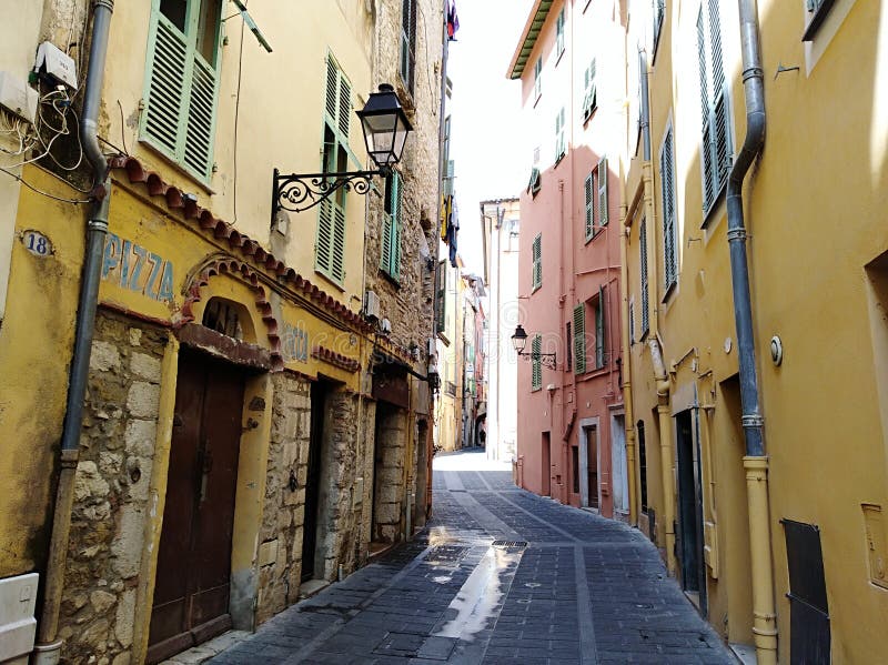 Alley in Menton stock image. Image of lamp, building - 12504877