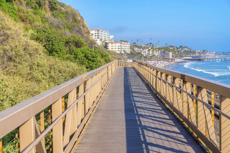 Narrow bridge with yellow railings near the mountain slope at the coastal area of San Clemente, CA