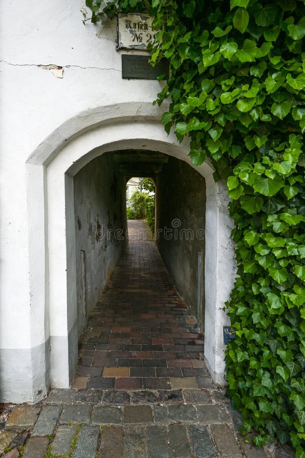 Narrow entrance tunnel to a small residential alley, typical tourist destination in the medieval old town of Luebeck, Germany royalty free stock image Narrow entrance tunnel to a small residential alley, typical tourist destination in the medieval old town of Luebeck, Germany royalty free stock image