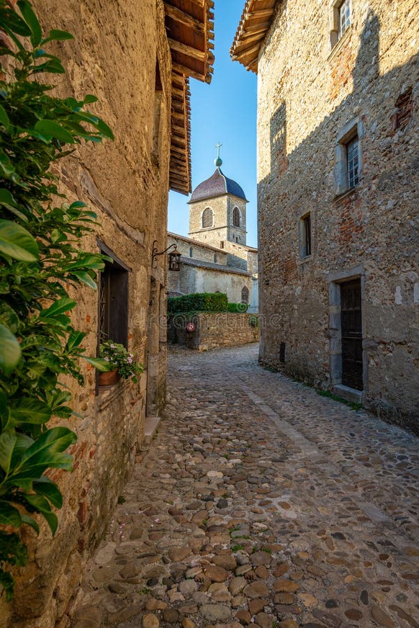 Narrow street framing a view of the church steeple, Perouges, F