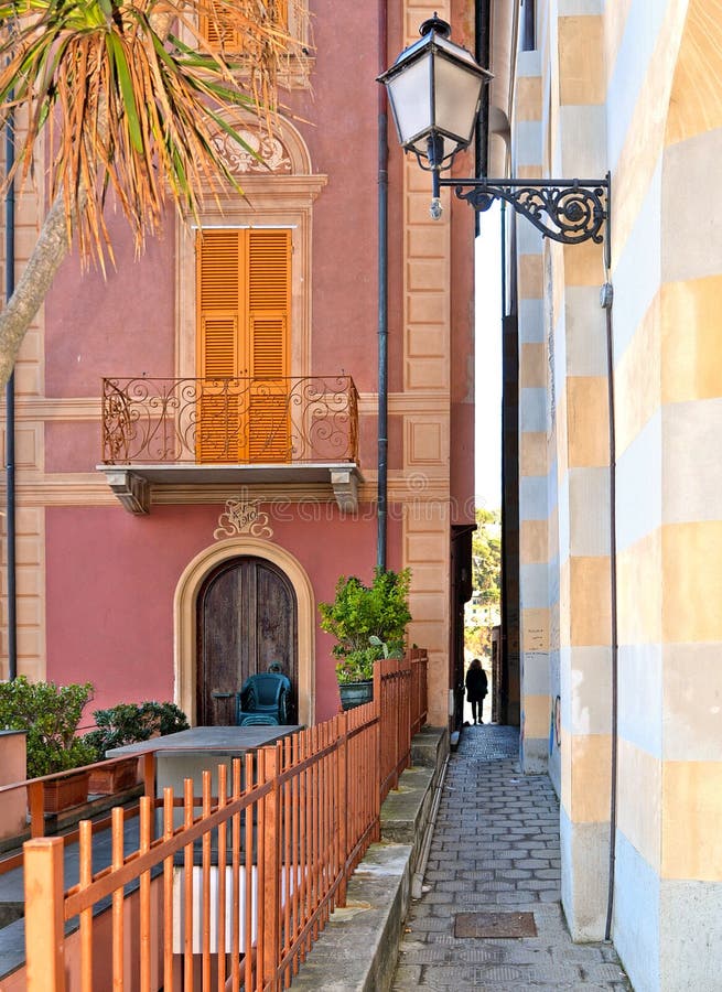Narrow street with woman silhouette and colorful old buildings in old small coastal town Sestri Levante in Liguria, Italy stock photo Narrow street with woman silhouette and colorful old buildings in old small coastal town Sestri Levante in Liguria, Italy stock photo