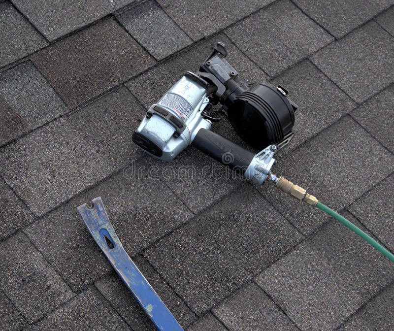 A nailgun and pry bar are two tools used by a roofer when reparing shingles on a roof: Prybar to pull nails and shingles; nailgun to secure new shingles in place. A nailgun and pry bar are two tools used by a roofer when reparing shingles on a roof: Prybar to pull nails and shingles; nailgun to secure new shingles in place.