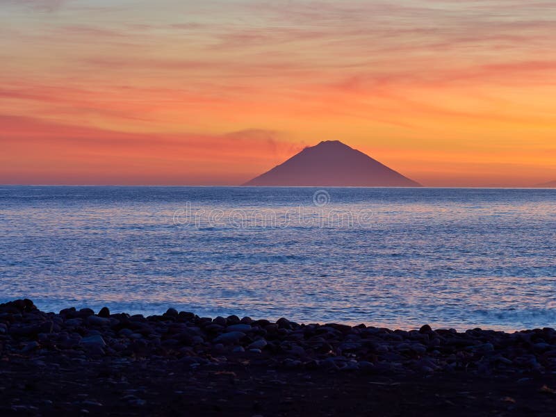 Nascer do sol bonito com a ilha de Stromboli vista da ilha do Salina nas ilhas eólias, Sicília, Itália imagem de stock Nascer do sol bonito com a ilha de Stromboli vista da ilha do Salina nas ilhas eólias, Sicília, Itália imagem de stock